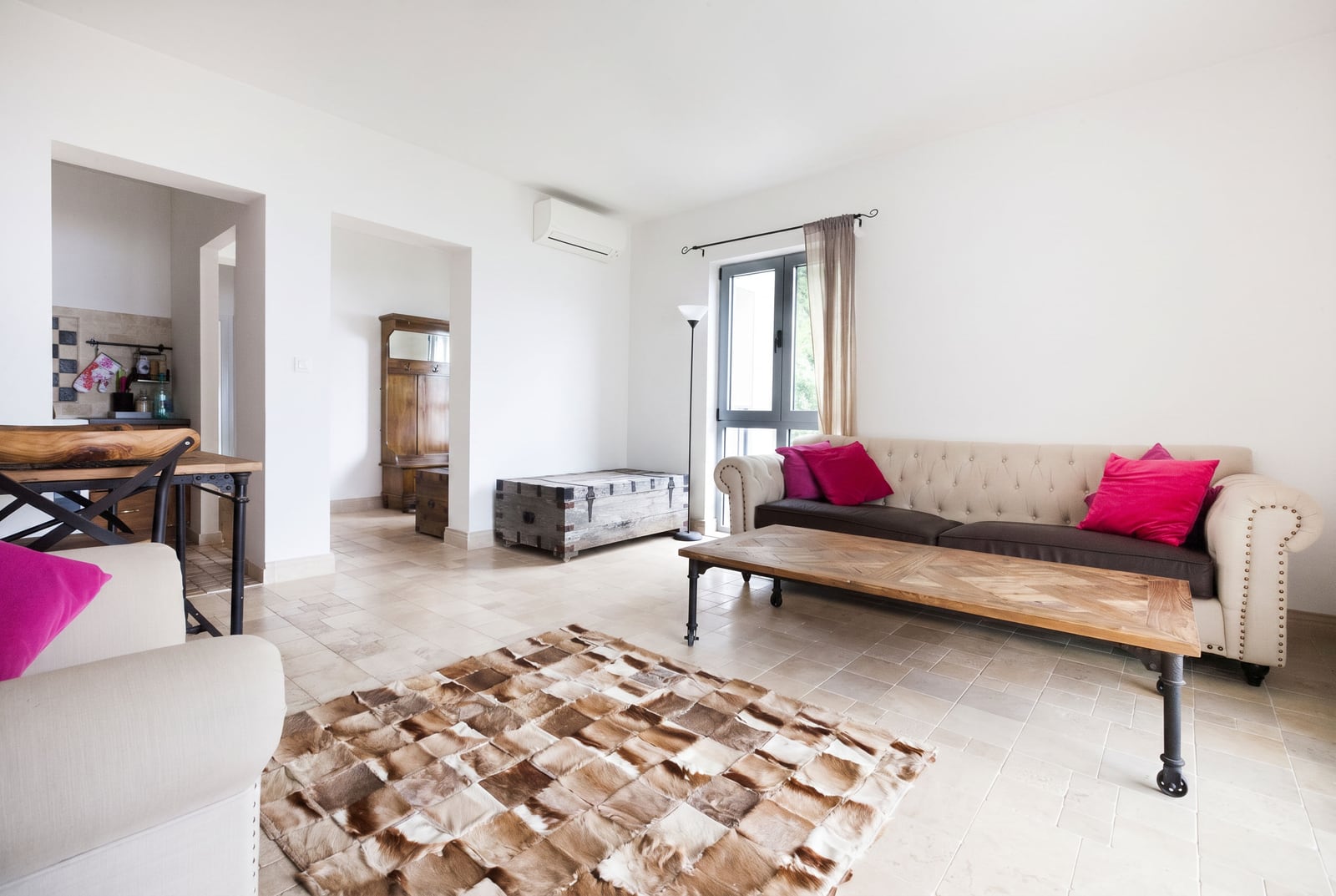 Bright living room in an apartment in Risan, Montenegro: beige sofa, wooden coffee table, and a fur rug on the floor.
