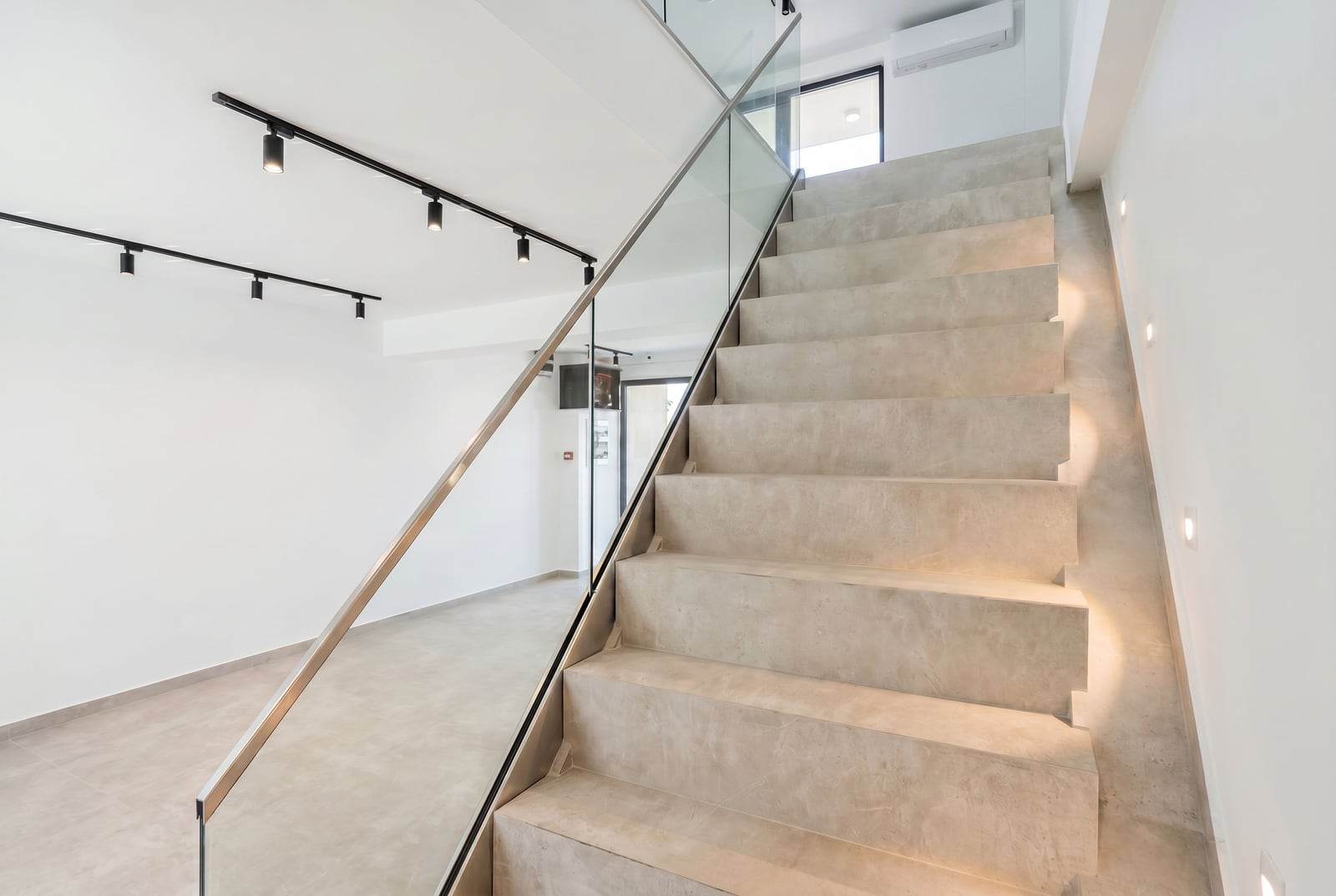 Modern staircase with lighting and glass railing in an office space, Budva, Montenegro.