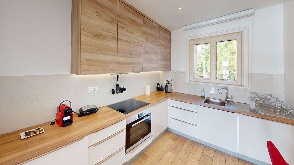 Modern kitchen with wooden fronts and built-in appliances in an apartment, Luštica, Montenegro.