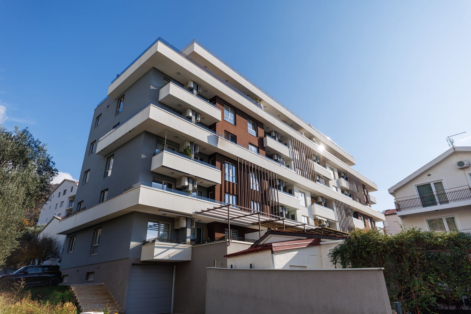 Modern residential complex in Bečići, Montenegro: facade of an apartment building with balconies and panoramic windows.