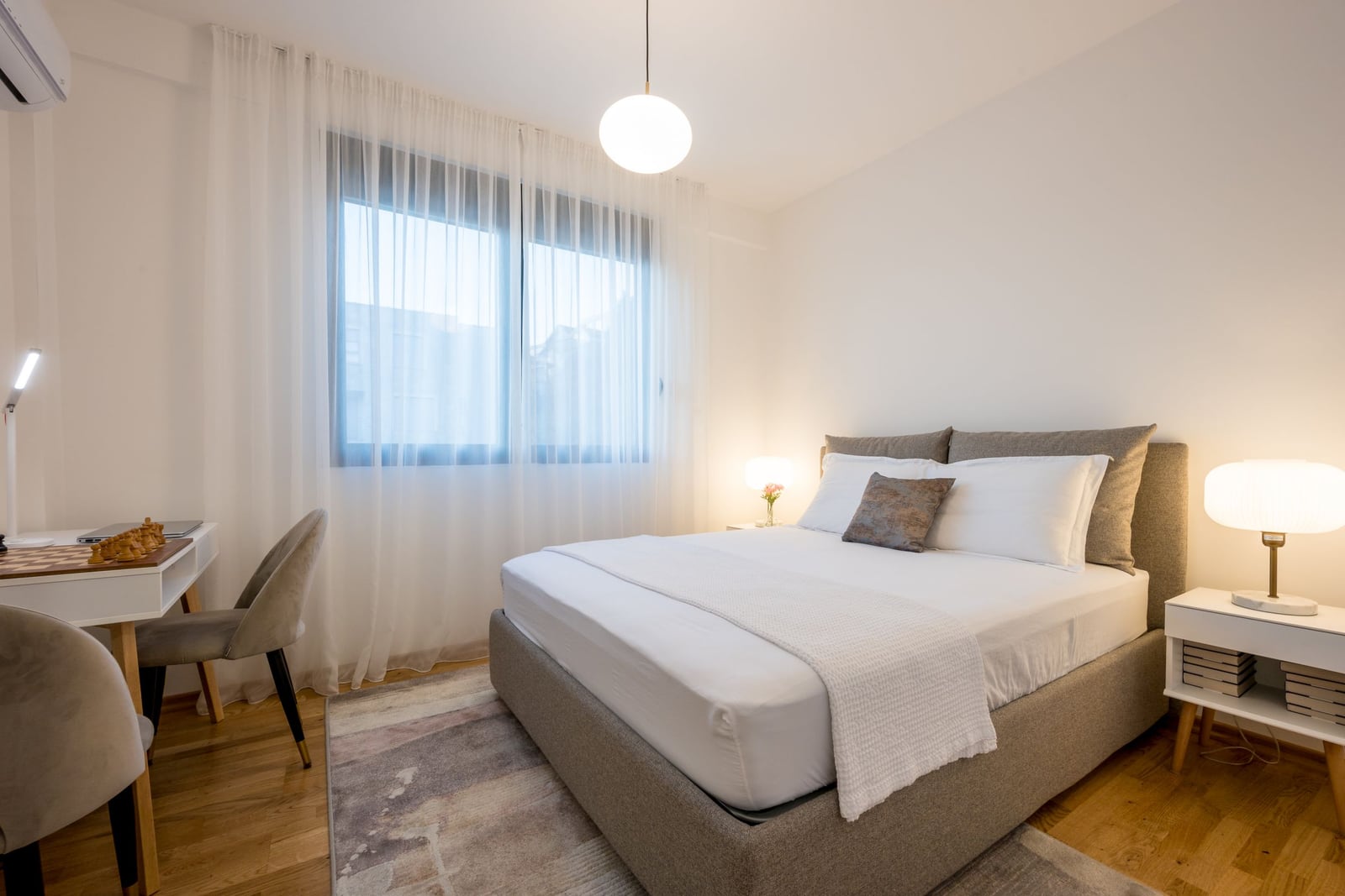 Cozy bedroom with a double bed and a workspace in a modern apartment, Tivat, Montenegro.