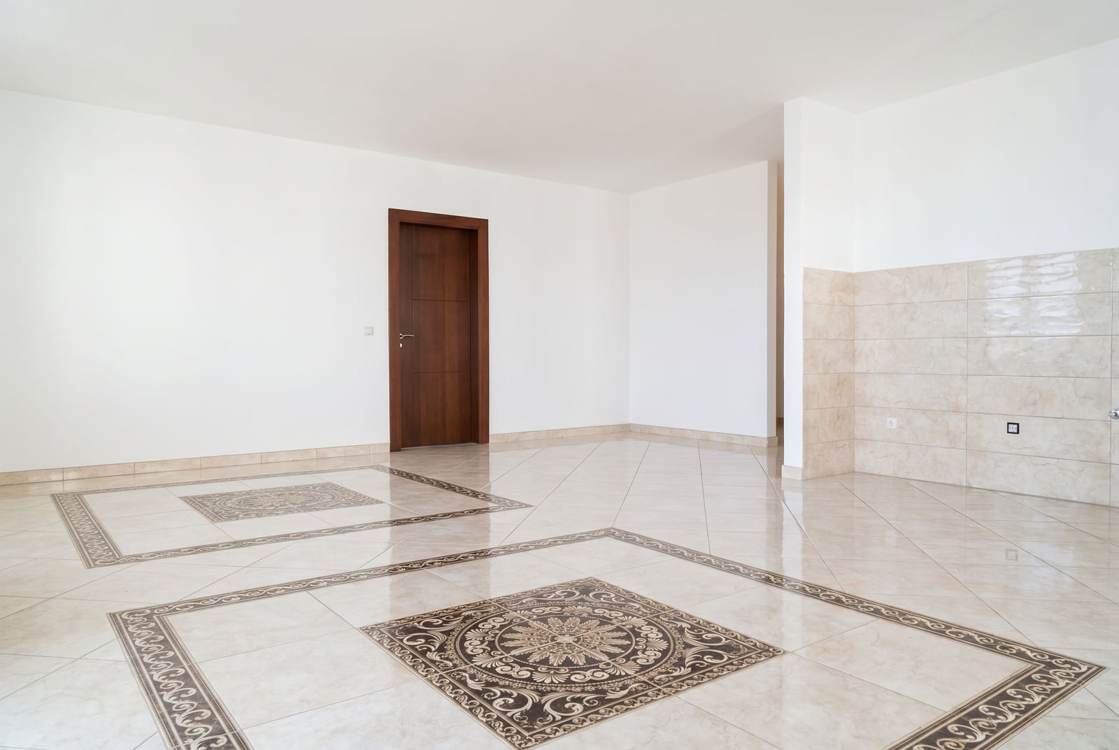 Spacious and bright living room in an apartment in Bečići, Montenegro: decorative tiled floor and dark interior door.