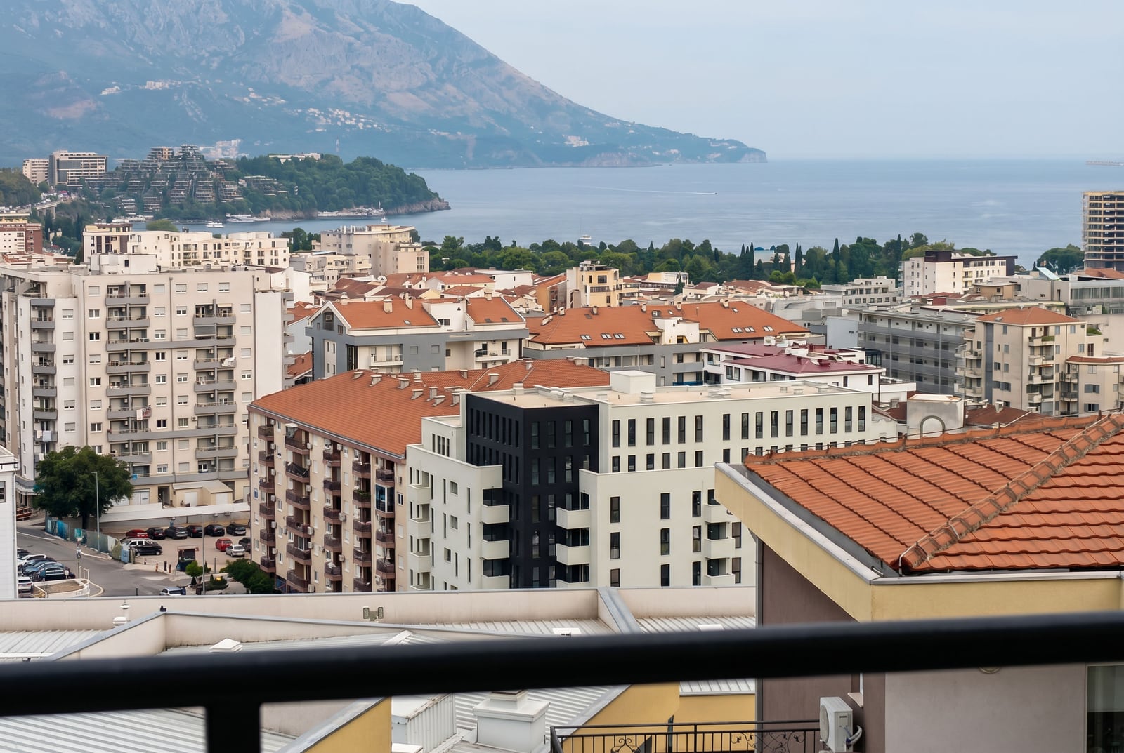 Panoramic view of the city, sea, and mountains from the balcony of an apartment in Budva, Montenegro.