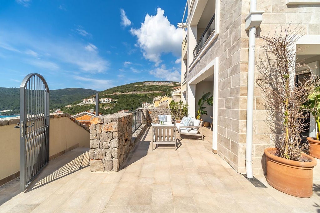 Spacious terrace with garden furniture and mountain views in a residential complex, Luštica, Montenegro.