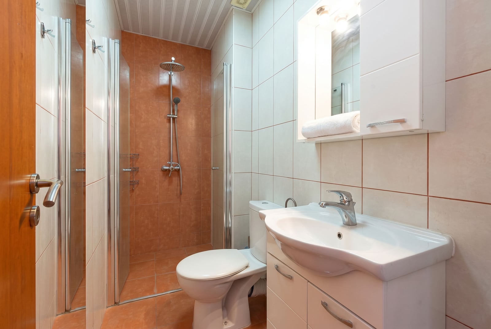 Bathroom with a walk-in shower and light-colored furniture in a villa, Becici, Montenegro. Modern tile finishes.