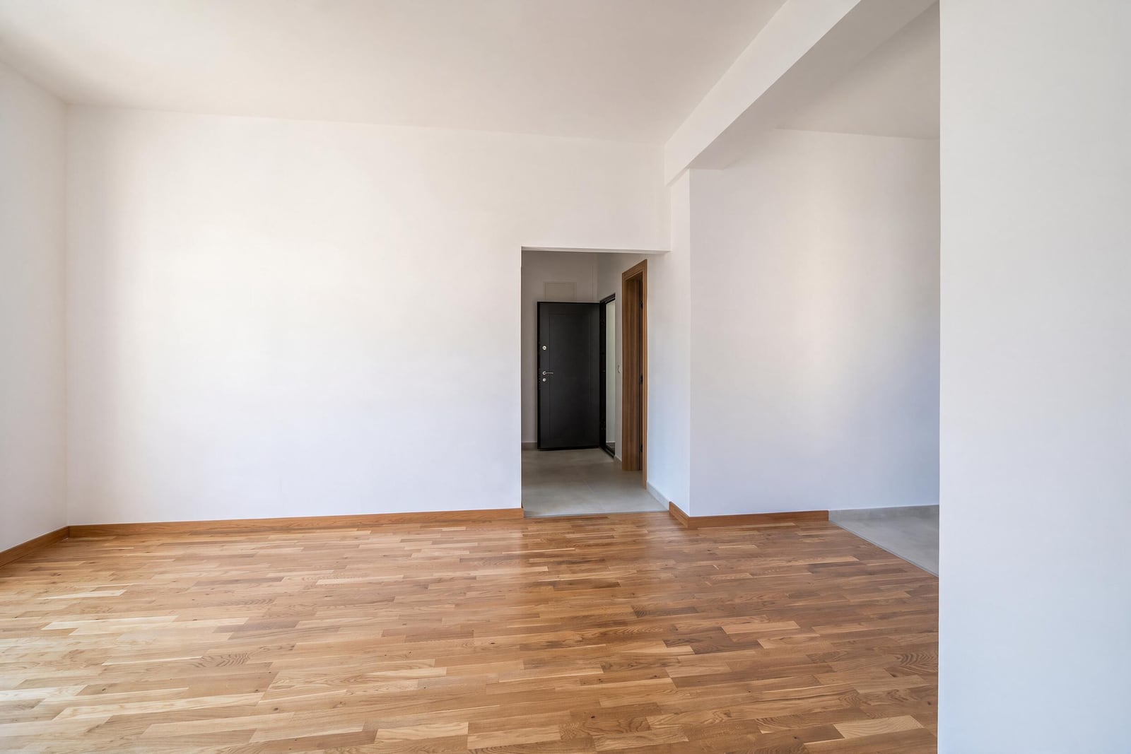 Bright living room with parquet flooring and white walls in an apartment in the city of Bar, Montenegro.