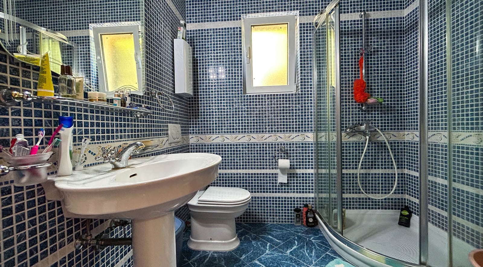 Bathroom with blue mosaic tile and a shower cabin in a villa in Dobrota, Montenegro.