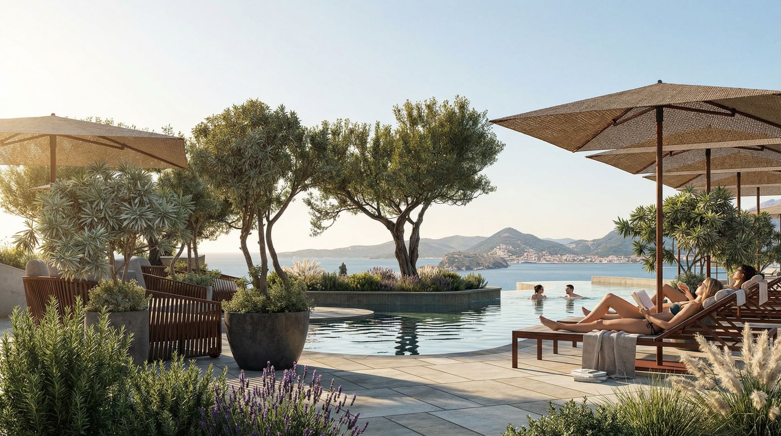 Infinity pool with lounge chairs and umbrellas overlooking the sea and mountains.