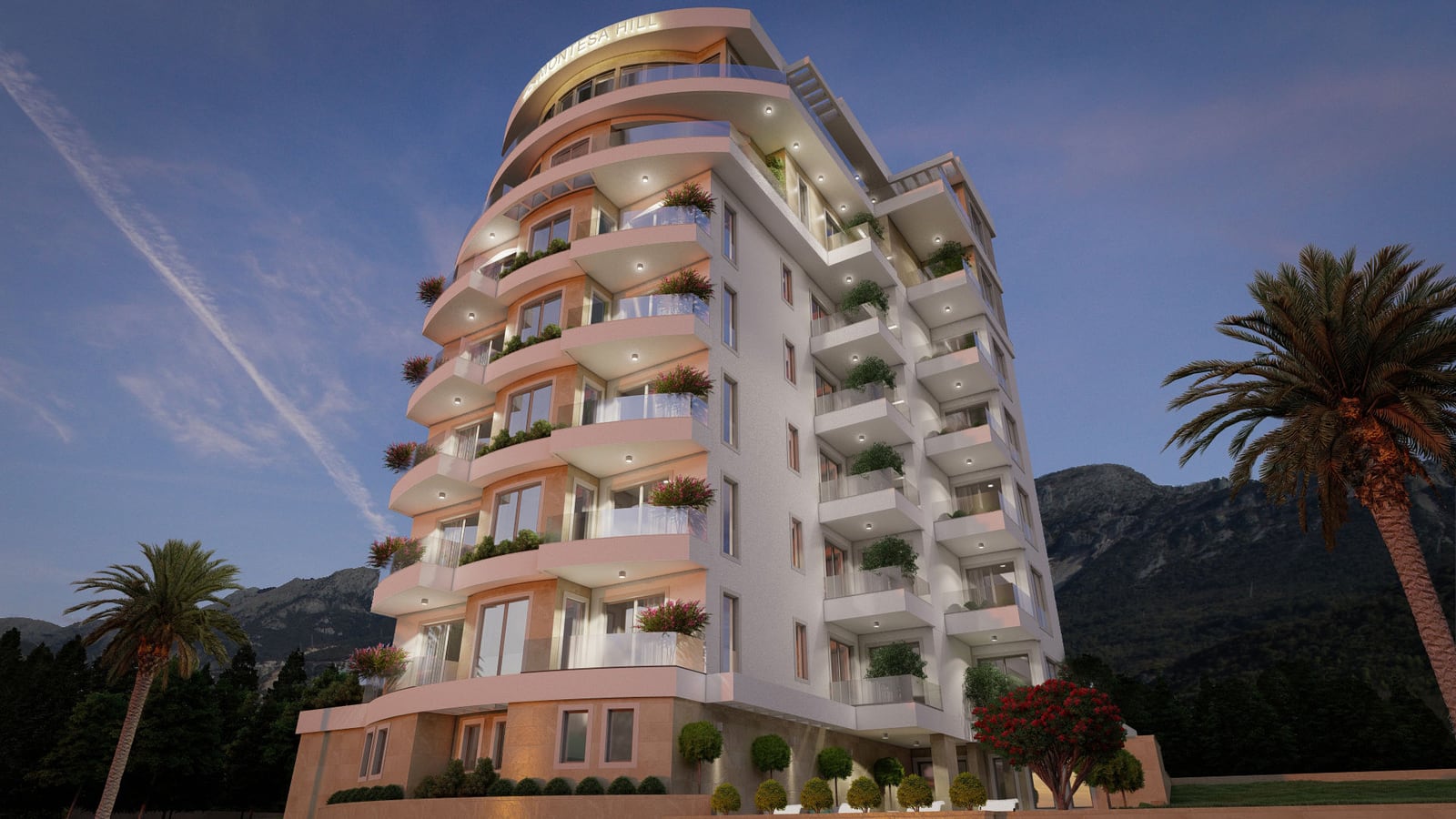 Exterior view of a modern multi-story residential building with balconies against mountains and palm trees.