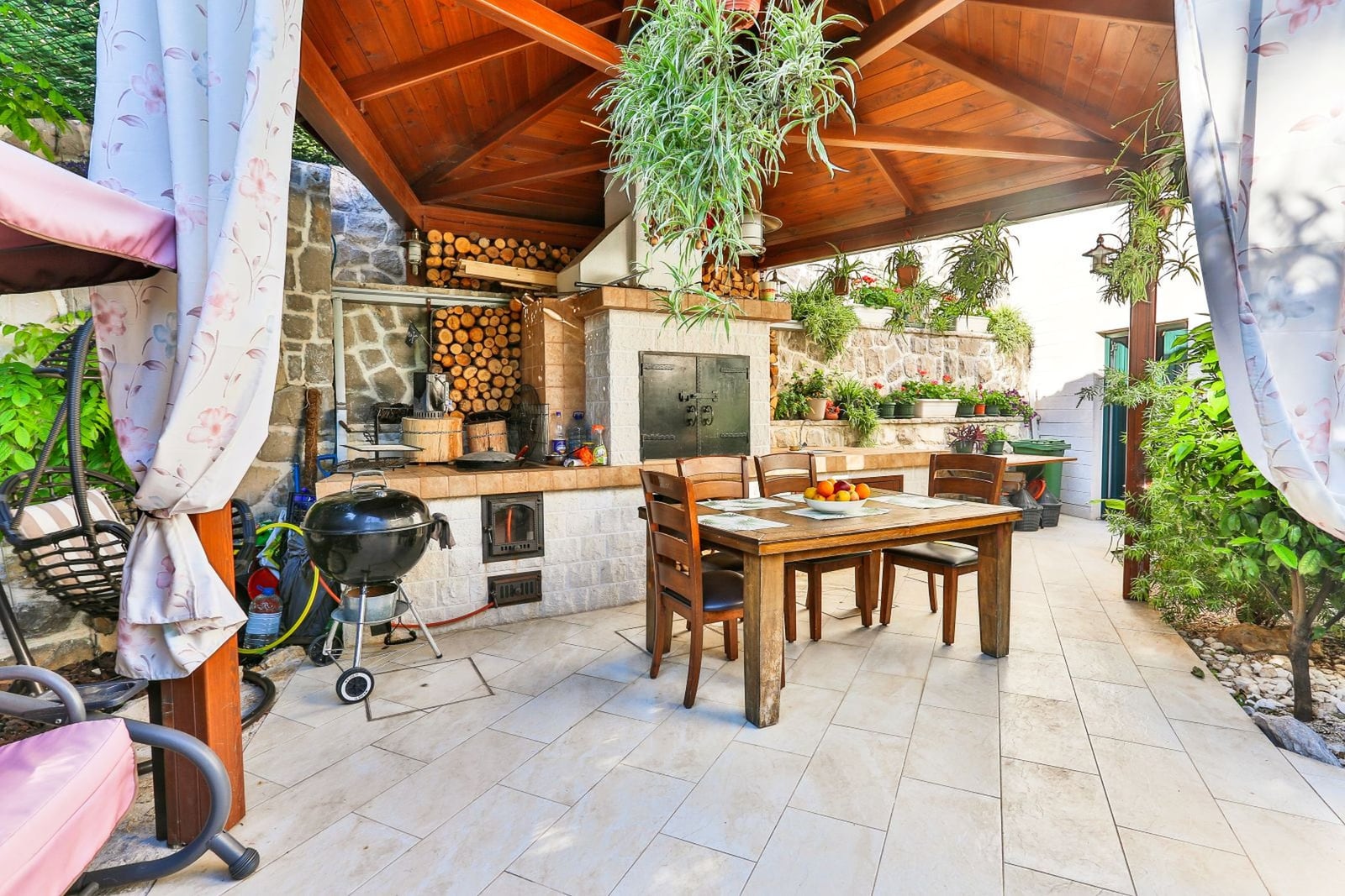 Covered terrace with barbecue, stone finish, and dining area at a villa in Tivat, Montenegro.