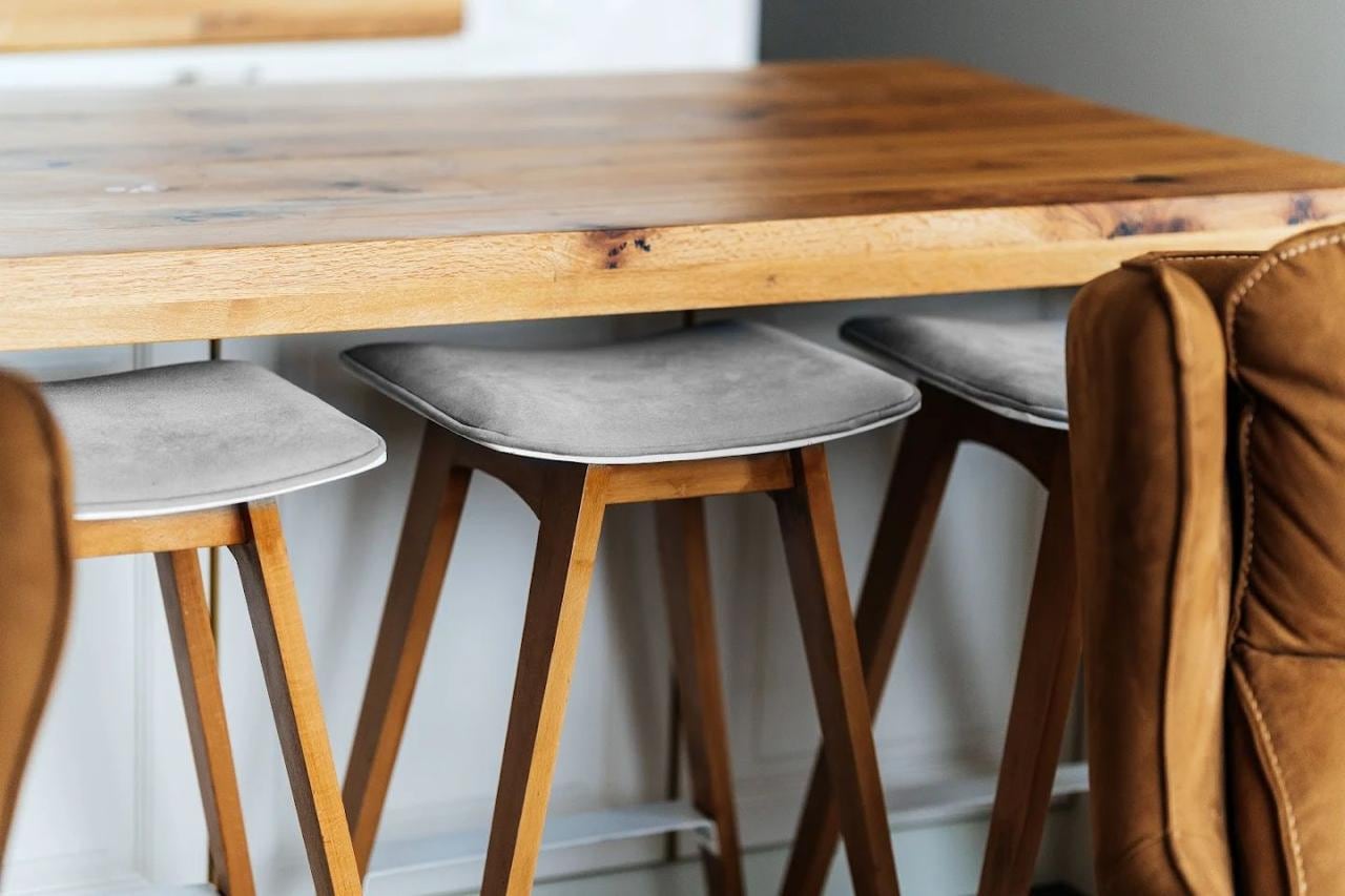 A natural wood bar counter and gray chairs in an apartment interior in Budva, Montenegro.
