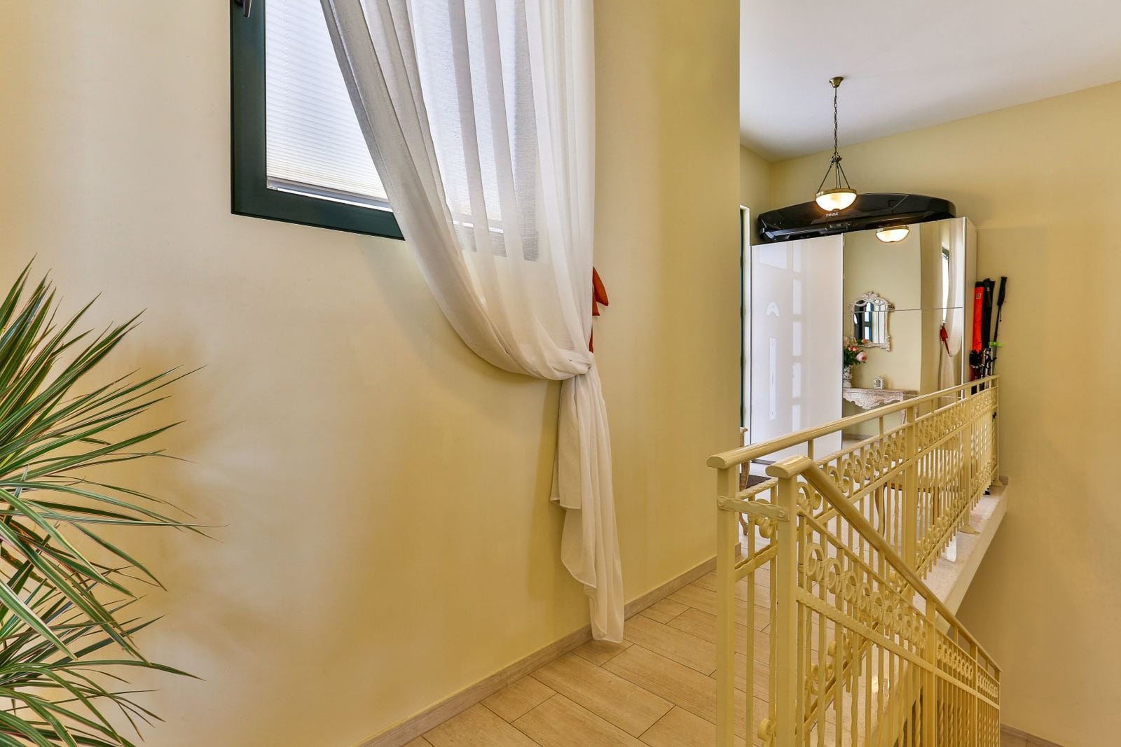 Bright hallway with wrought iron railings and a mirrored wardrobe in a villa in Tivat, Montenegro.