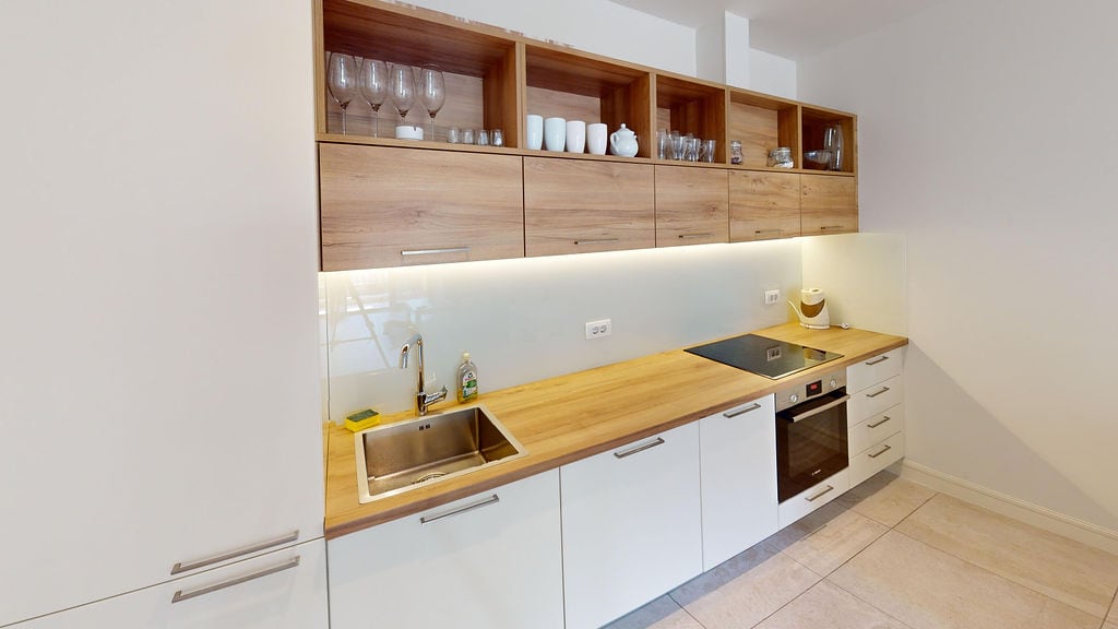 Modern kitchen with wooden facades and built-in appliances in an apartment at Lustica Bay, Montenegro.