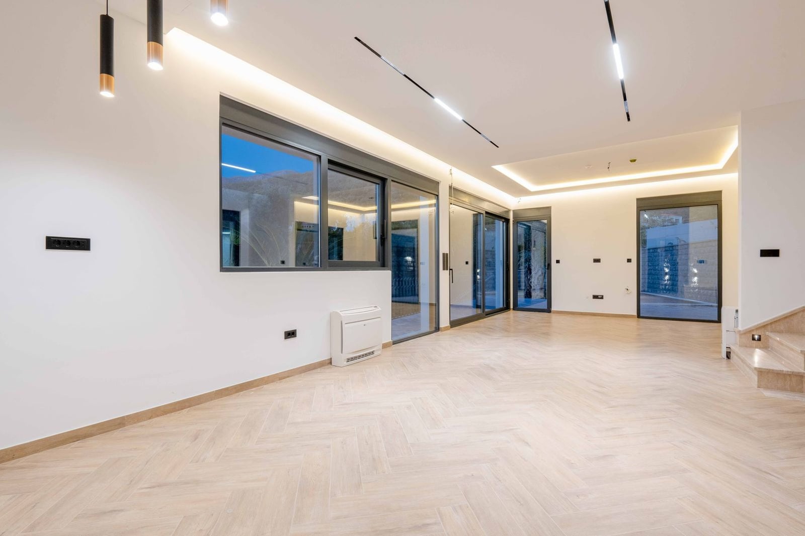 Spacious living room with panoramic windows and parquet flooring in a new villa, Kamenovo, Montenegro. Modern interior design.