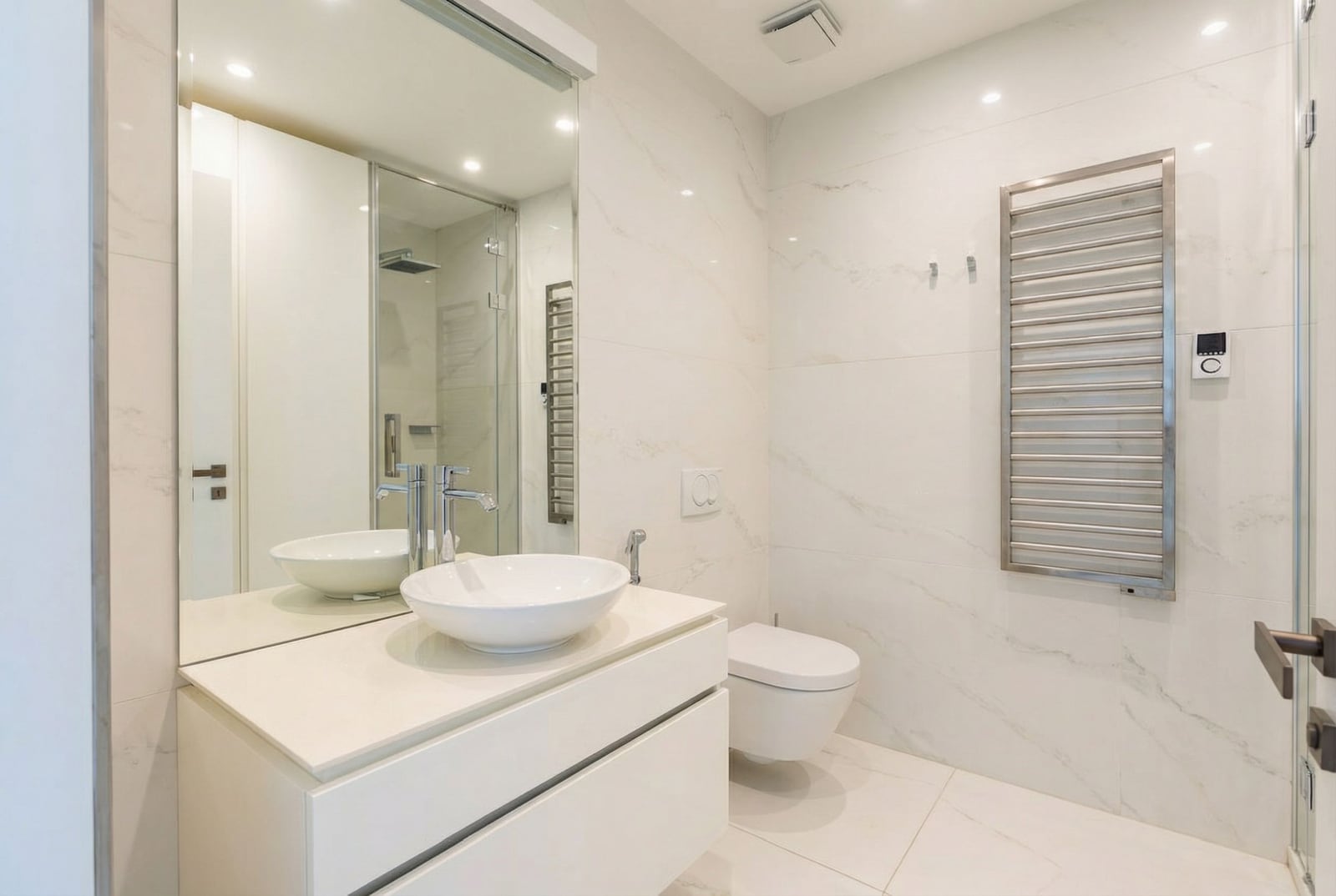 Modern bathroom in a Dukley apartment, Budva, Montenegro: light tiles, vessel sink, and shower.