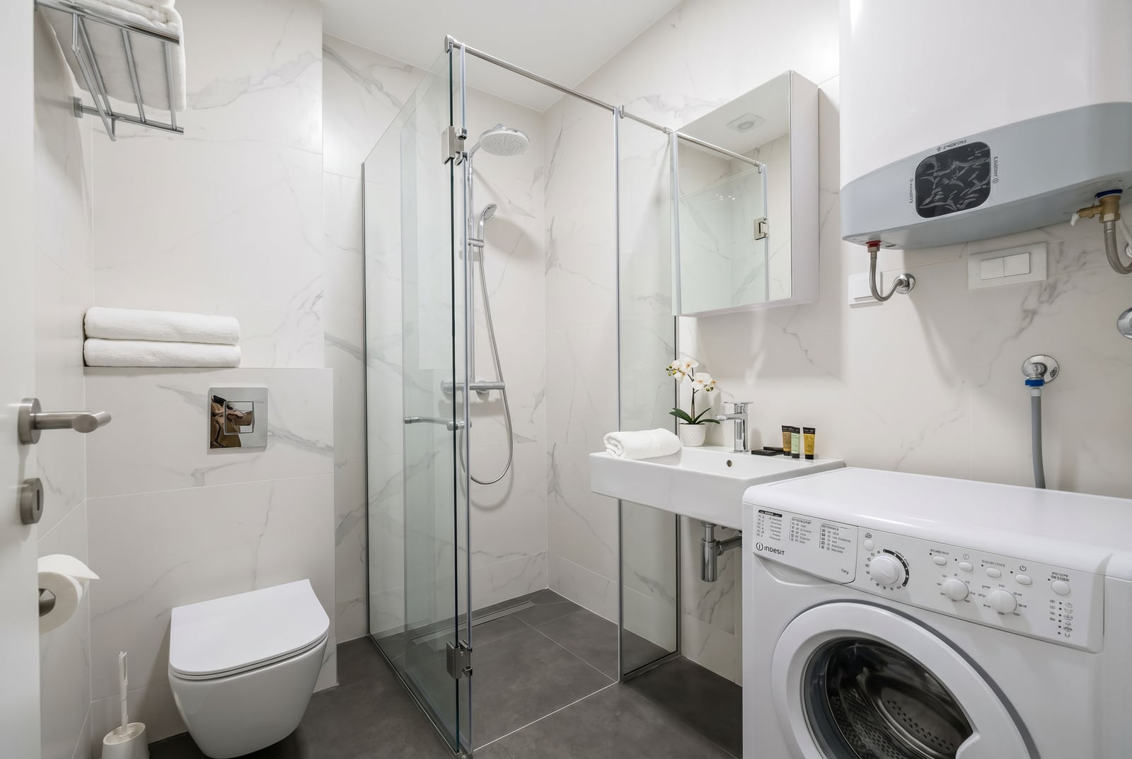 Modern bathroom with a shower cabin and a washing machine in an apartment, Becici, Montenegro.