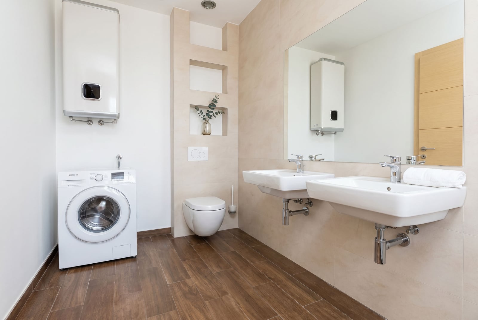 Modern bathroom with double sinks and a washing machine in an apartment, Budva, Montenegro.
