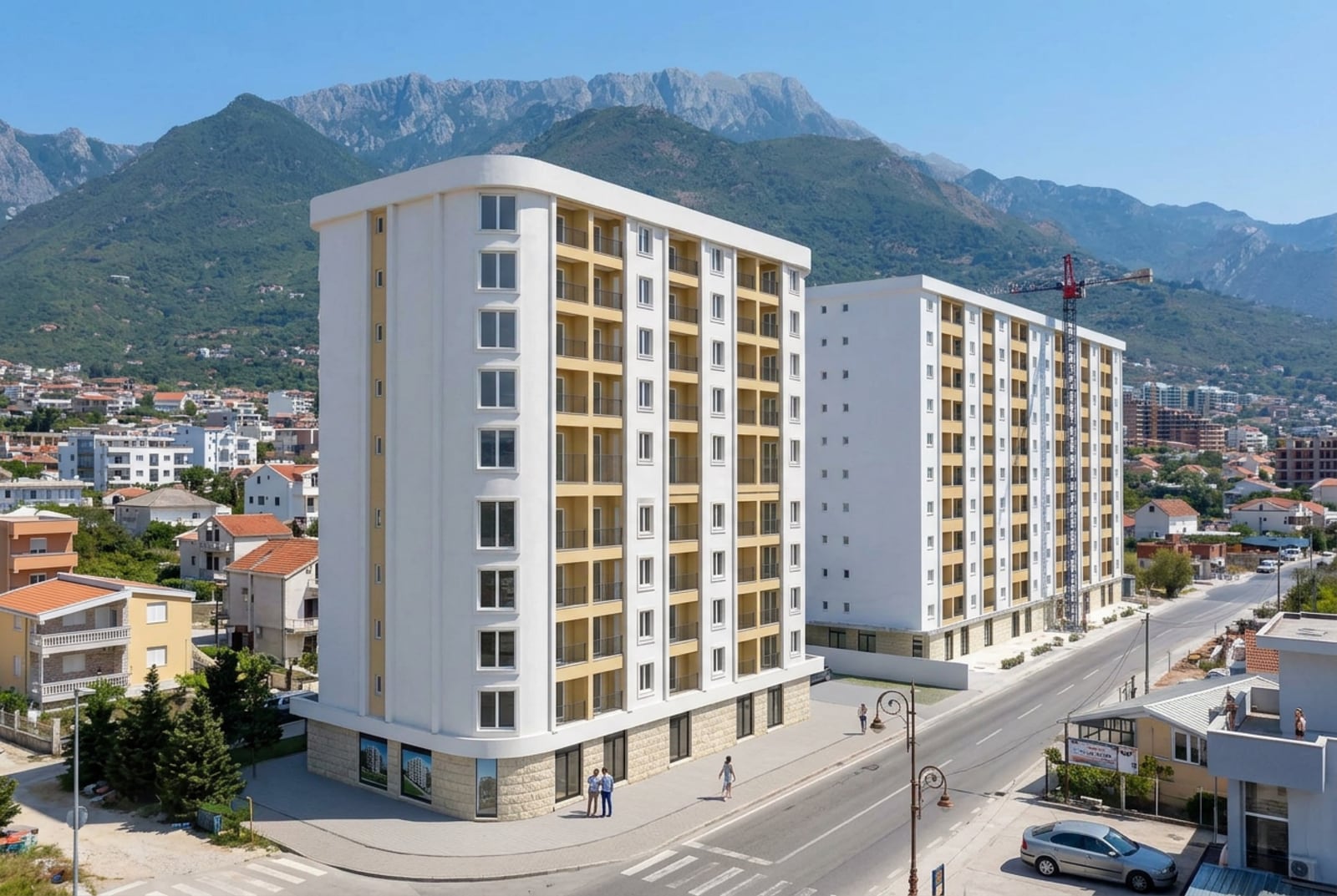Modern residential complex in Bar, Montenegro: view of new apartment buildings with balconies against a mountain backdrop.