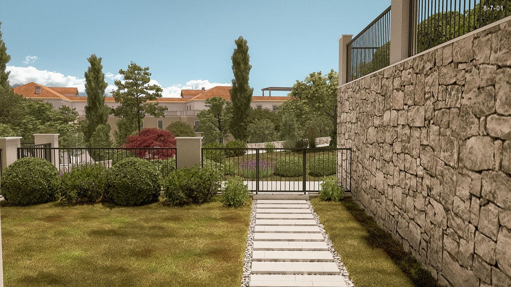 Well-maintained territory of a residential complex in Luštica, Montenegro: stone wall, pathway, and green garden near the house.