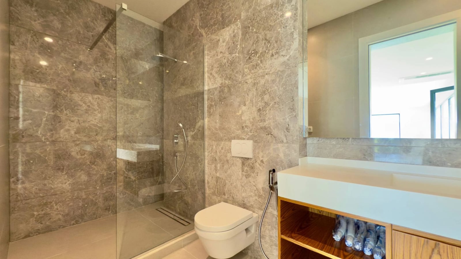 Modern bathroom with gray marble finishes in a villa, Krašići, Montenegro: shower and wall-mounted fixtures.