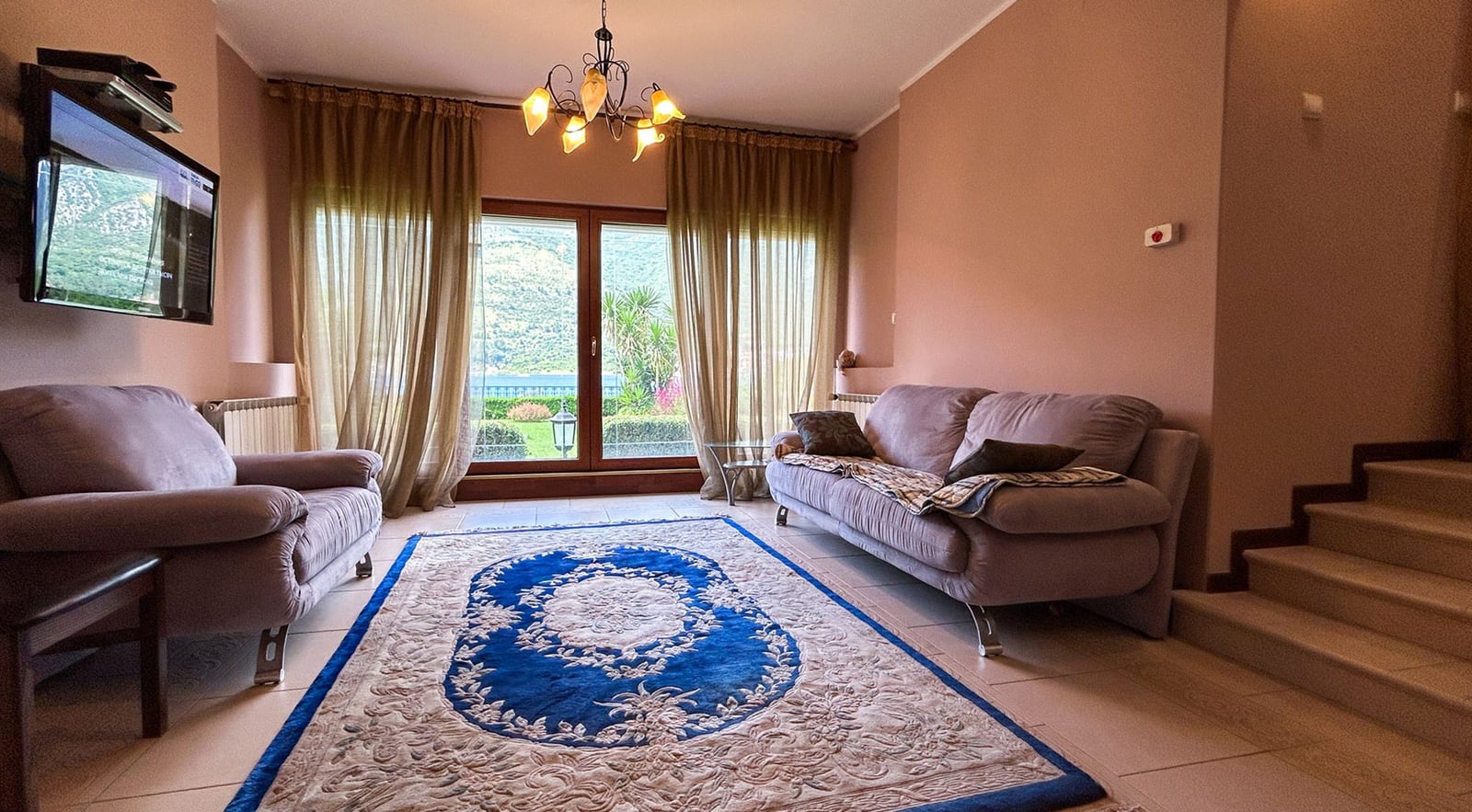 Cozy living room with soft furniture and panoramic sea views in a villa house in Dobrota, Montenegro.