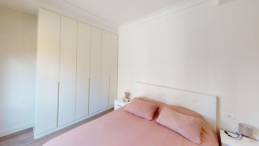 Bright bedroom with a large built-in wardrobe and a double bed in an apartment, Luštica, Montenegro.