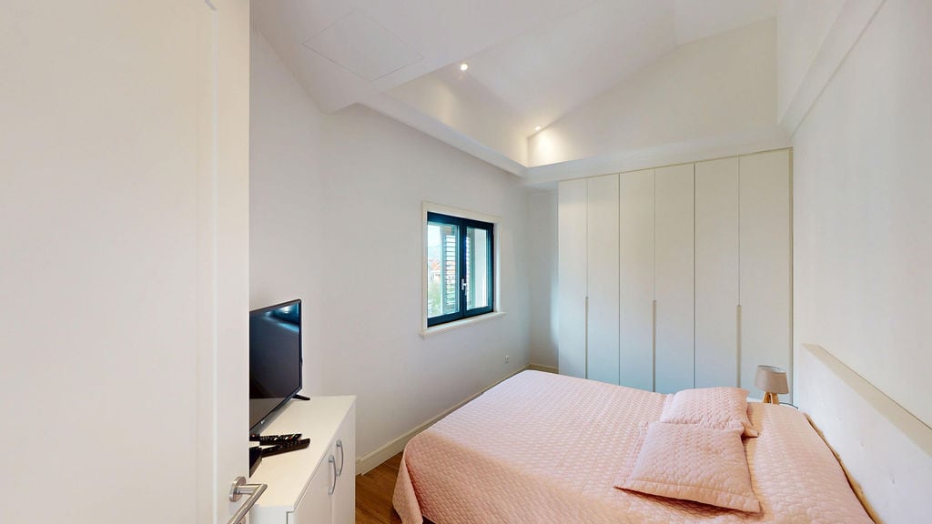 Bright bedroom with a double bed and built-in wardrobe in an apartment, Luštica, Montenegro.