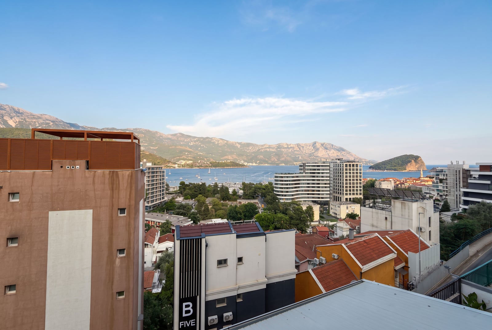 Panoramic view of the sea, mountains, and the city of Budva from the balcony of an apartment in Montenegro.