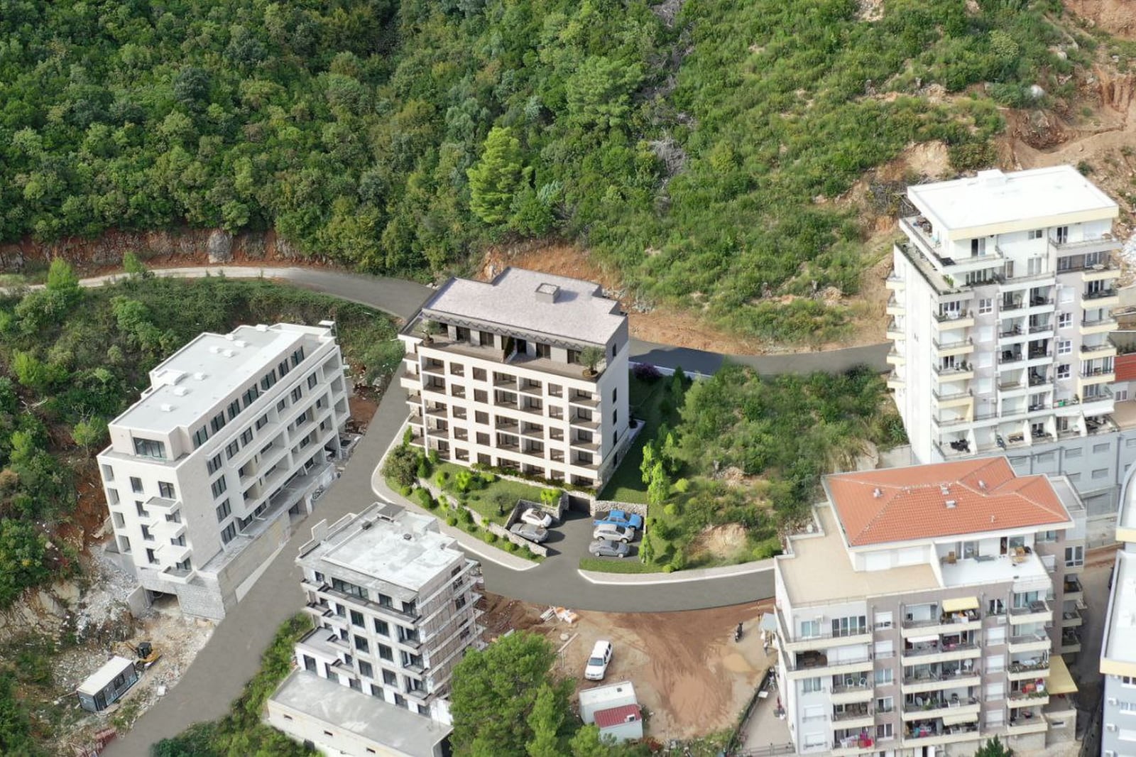 Aerial view of modern residential complexes in Budva, Montenegro, with landscaped grounds and parking.