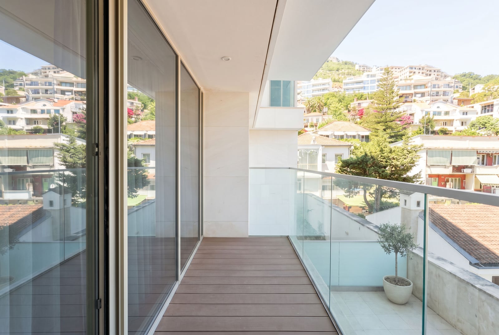 Spacious balcony with decking and glass railing in a modern apartment, Budva, Montenegro.