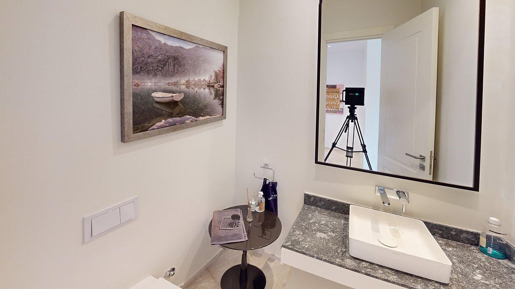 Modern bathroom in an apartment, Luštica, Montenegro: stone countertop, vessel sink, and painting.