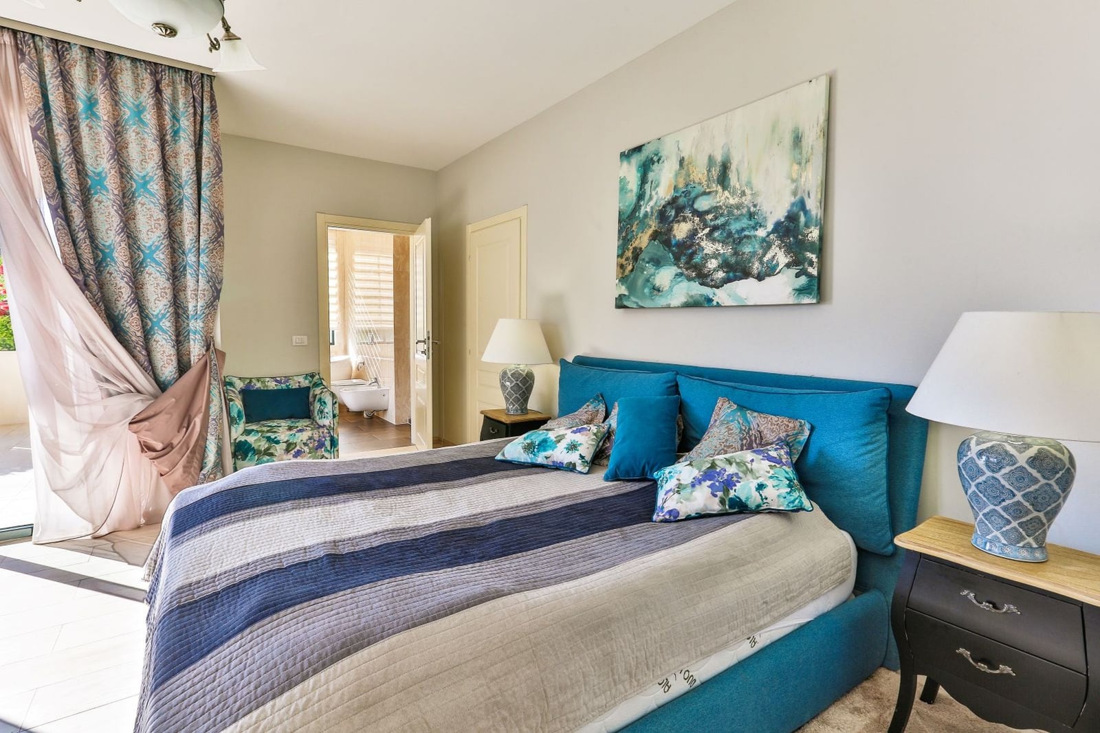 Cozy bedroom with a blue bed in a villa in Tivat, Montenegro: stylish interior, decor, and terrace access.