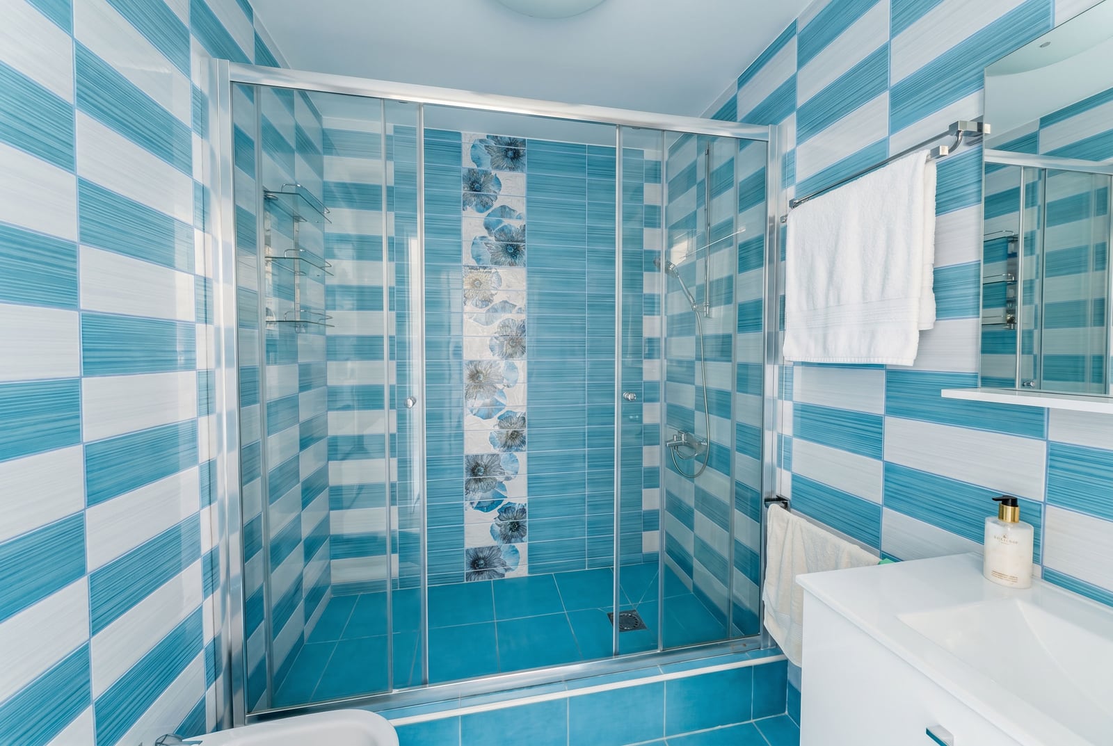 Bathroom with a shower cabin and blue and white tiles in an apartment for sale, Kumbor, Montenegro.