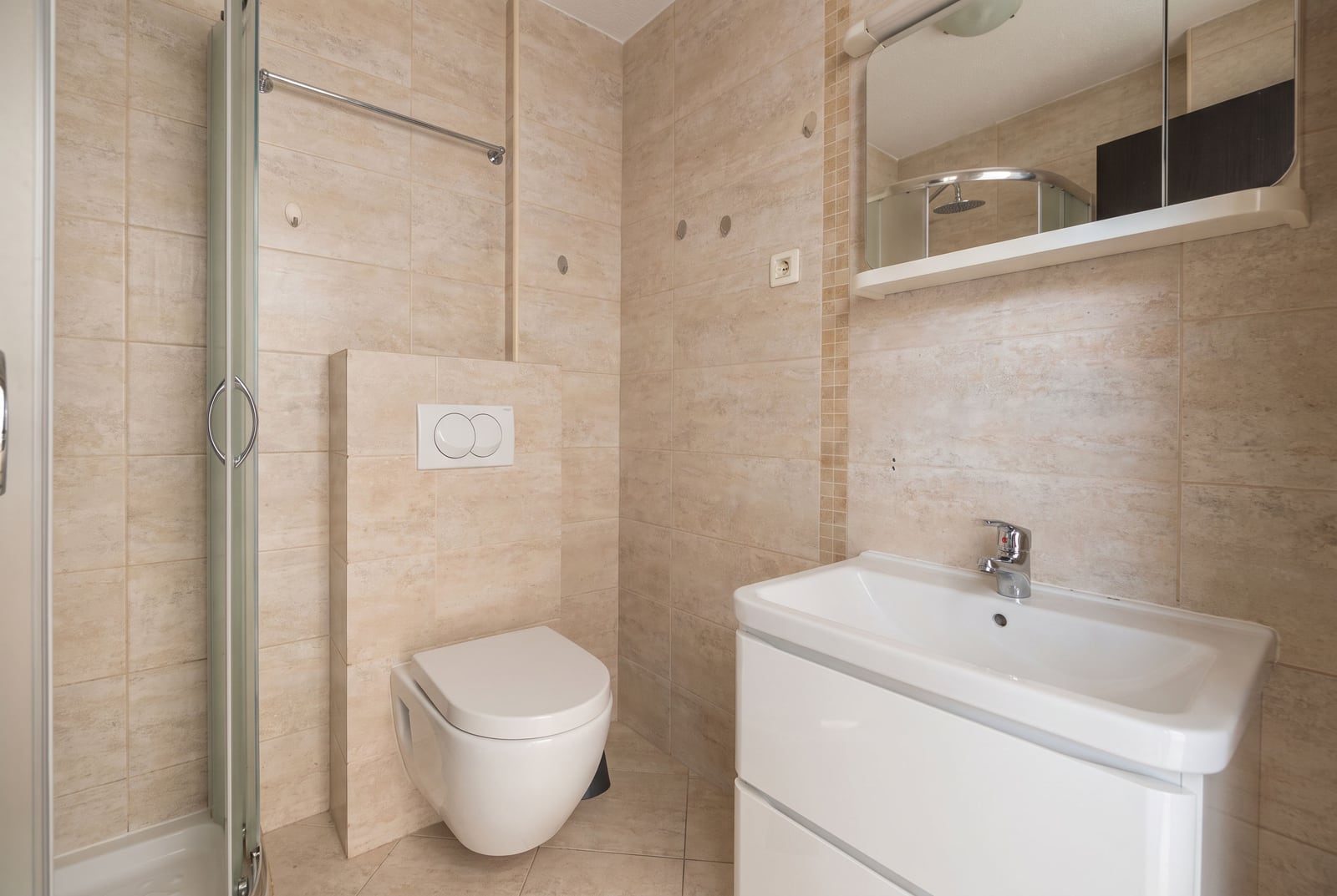 Modern bathroom with a shower enclosure and white fixtures in an apartment in Budva, Montenegro.