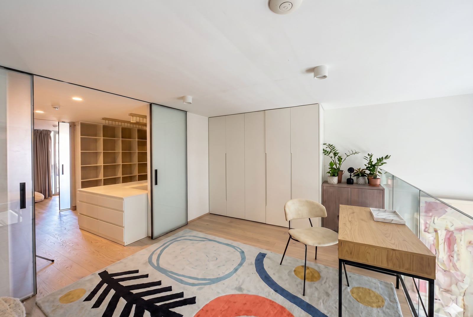 Modern living room with a walk-in closet and workspace in a Budva apartment, Montenegro: stylish furniture and bright interior.