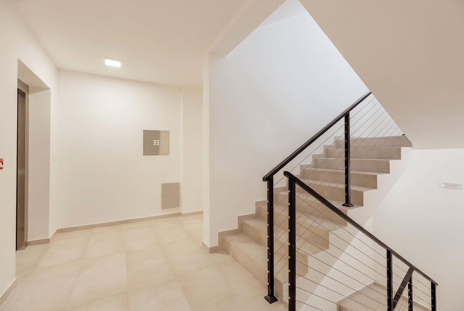 Modern landing with an elevator in a residential complex, Igalo, Montenegro: bright finishes and stylish railings.