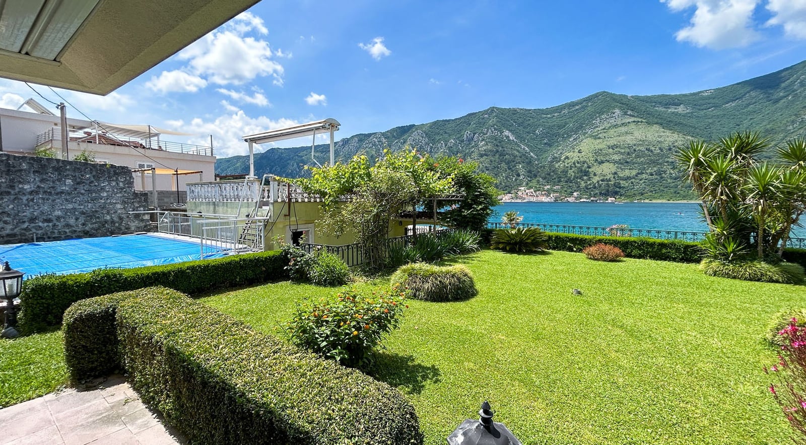Green garden with a pool and panoramic view of Kotor Bay, villa in Dobrota, Montenegro.