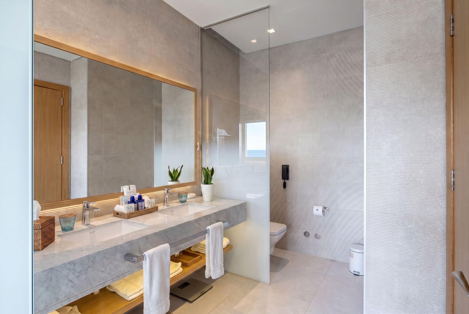Modern bathroom with a marble countertop at Luštica Bay, Montenegro: interior and shower view.
