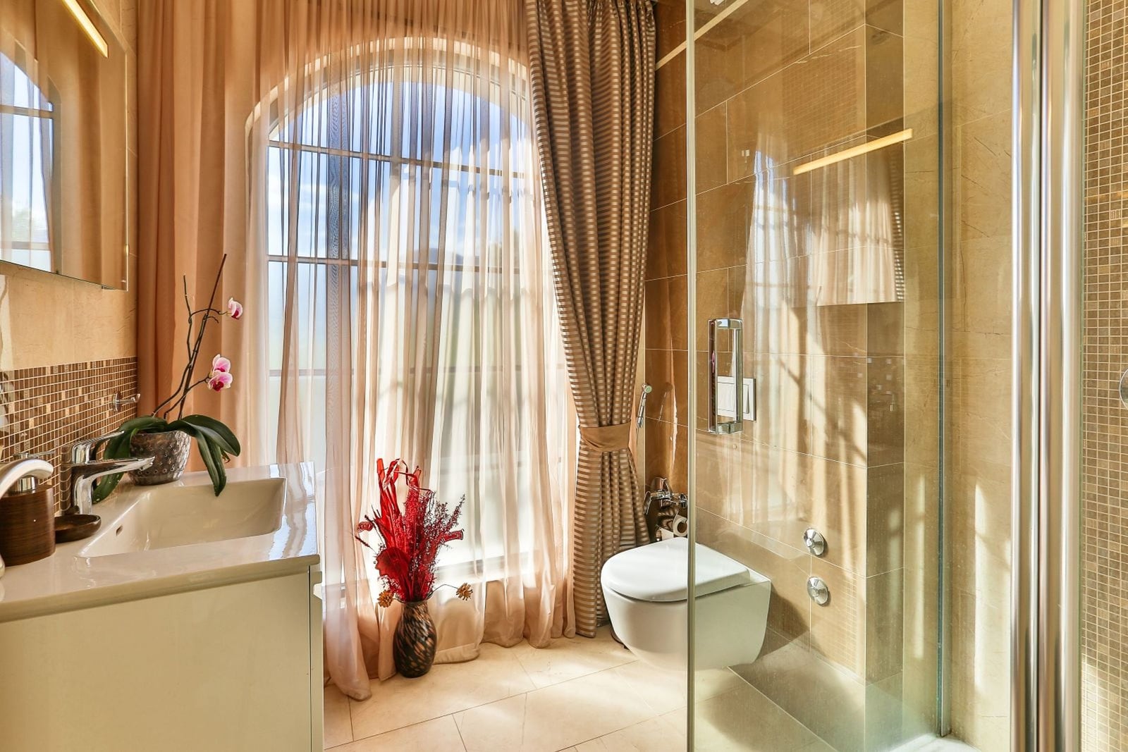 Bathroom with a shower cabin and an arched window in a luxury villa in Tivat, Montenegro. Modern tile finish.
