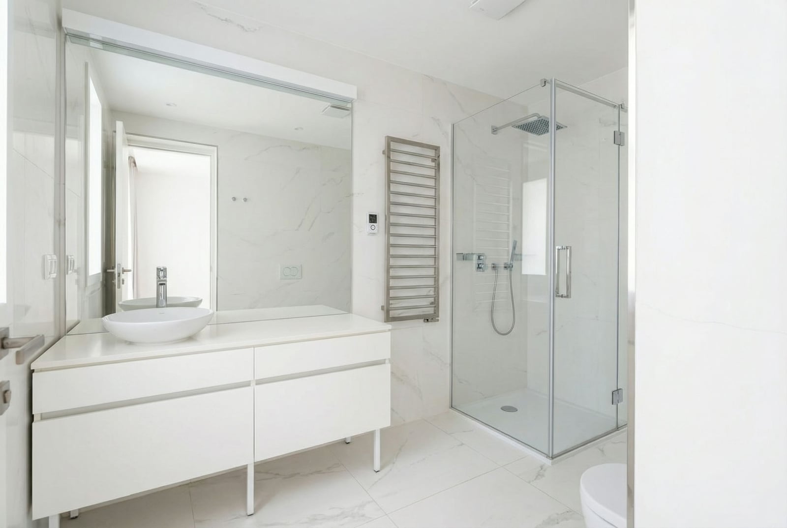 Modern bathroom in Dukley residential complex, Budva, Montenegro: white marble-look finishes, shower cabin, and stylish furniture.