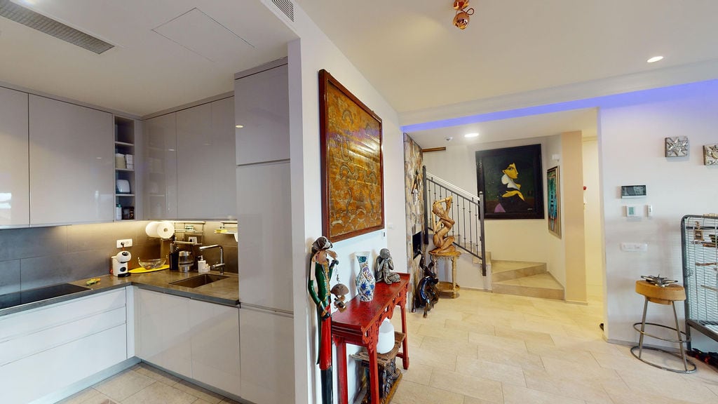 Modern kitchen in a townhouse, Luštica, Montenegro: glossy facades, stone finishes, and an interior staircase.