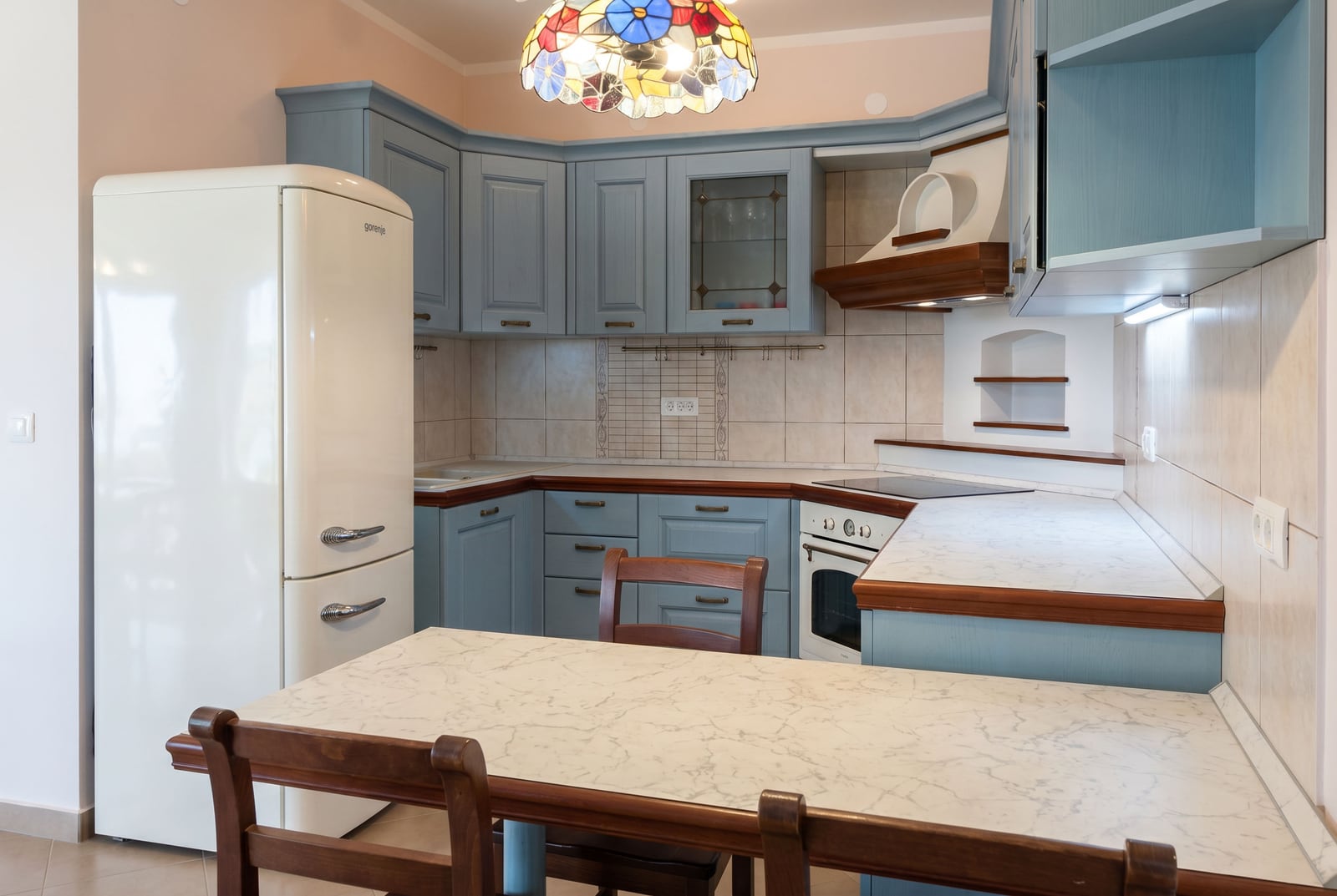 Kitchen in an apartment in Bar, Montenegro: blue cabinetry, vintage Gorenje refrigerator, and dining area.