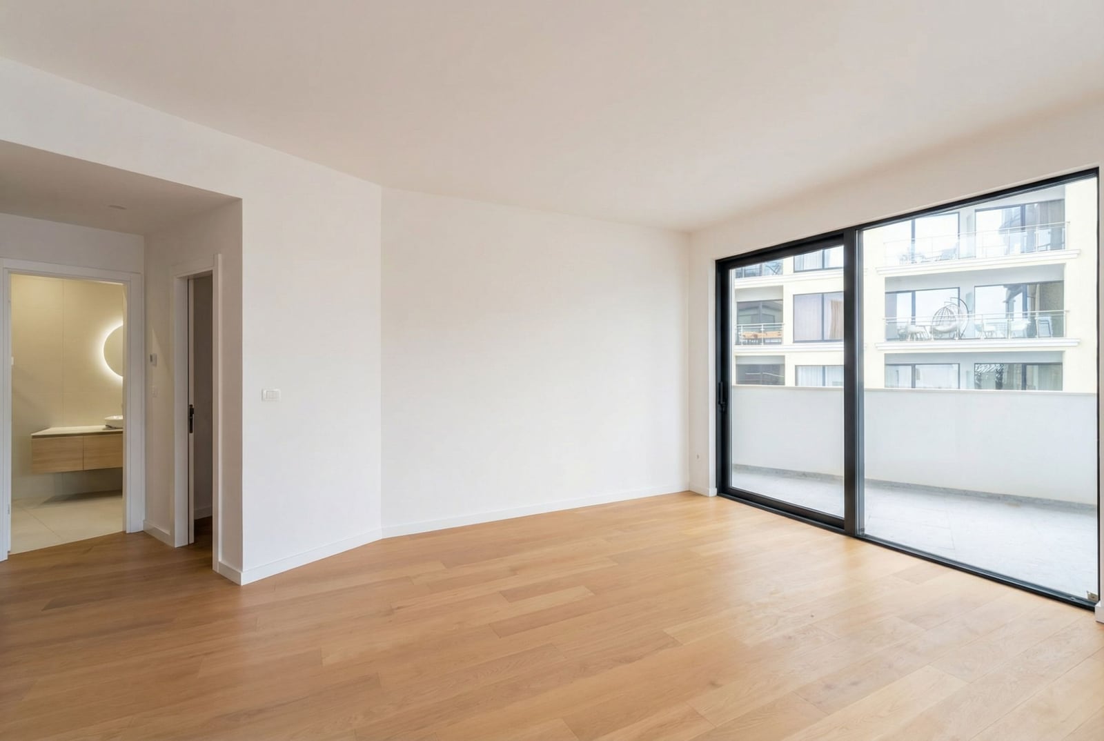 Bright living room with a panoramic window and access to the balcony in a new apartment, Becici, Montenegro.