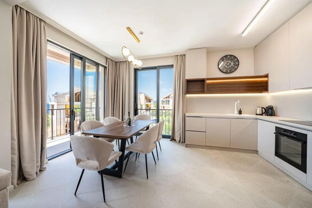 Modern kitchen and dining area in a villa in Reževići, Montenegro: bright interior, dining space, and panoramic windows.