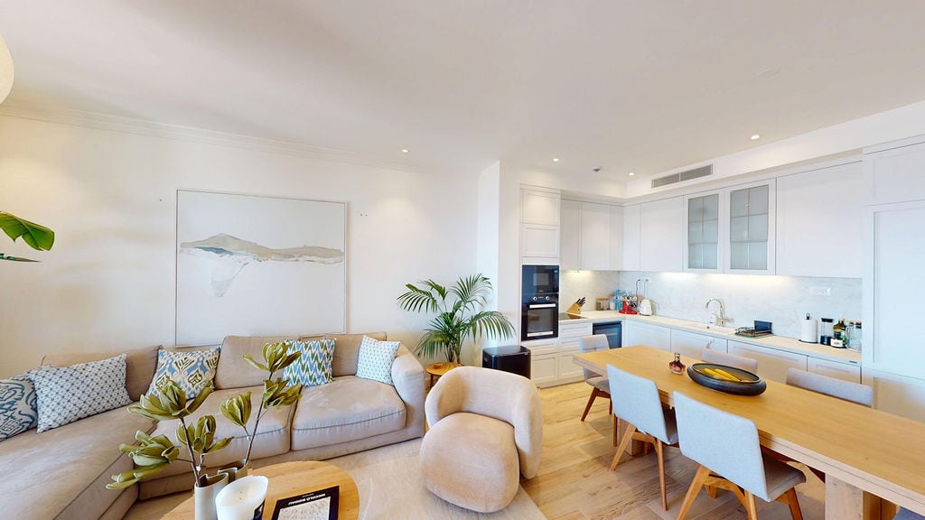 Modern living room with kitchen in an apartment, Luštica, Montenegro: light furniture, dining area, and stylish interior.