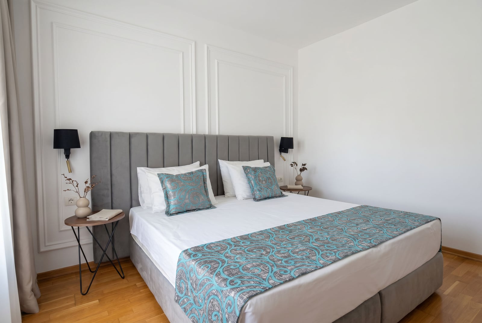 Modern bedroom with a double bed in an apartment in Bečići, Montenegro: stylish interior, wall moldings.