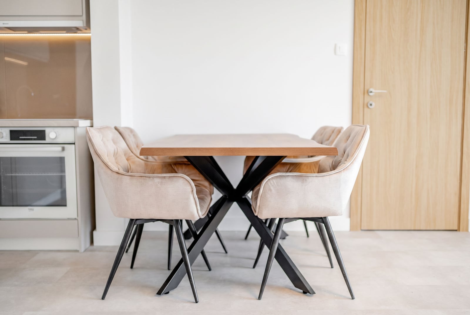 Modern dining area with a wooden table and upholstered chairs in an apartment, Sveti Stefan, Montenegro.