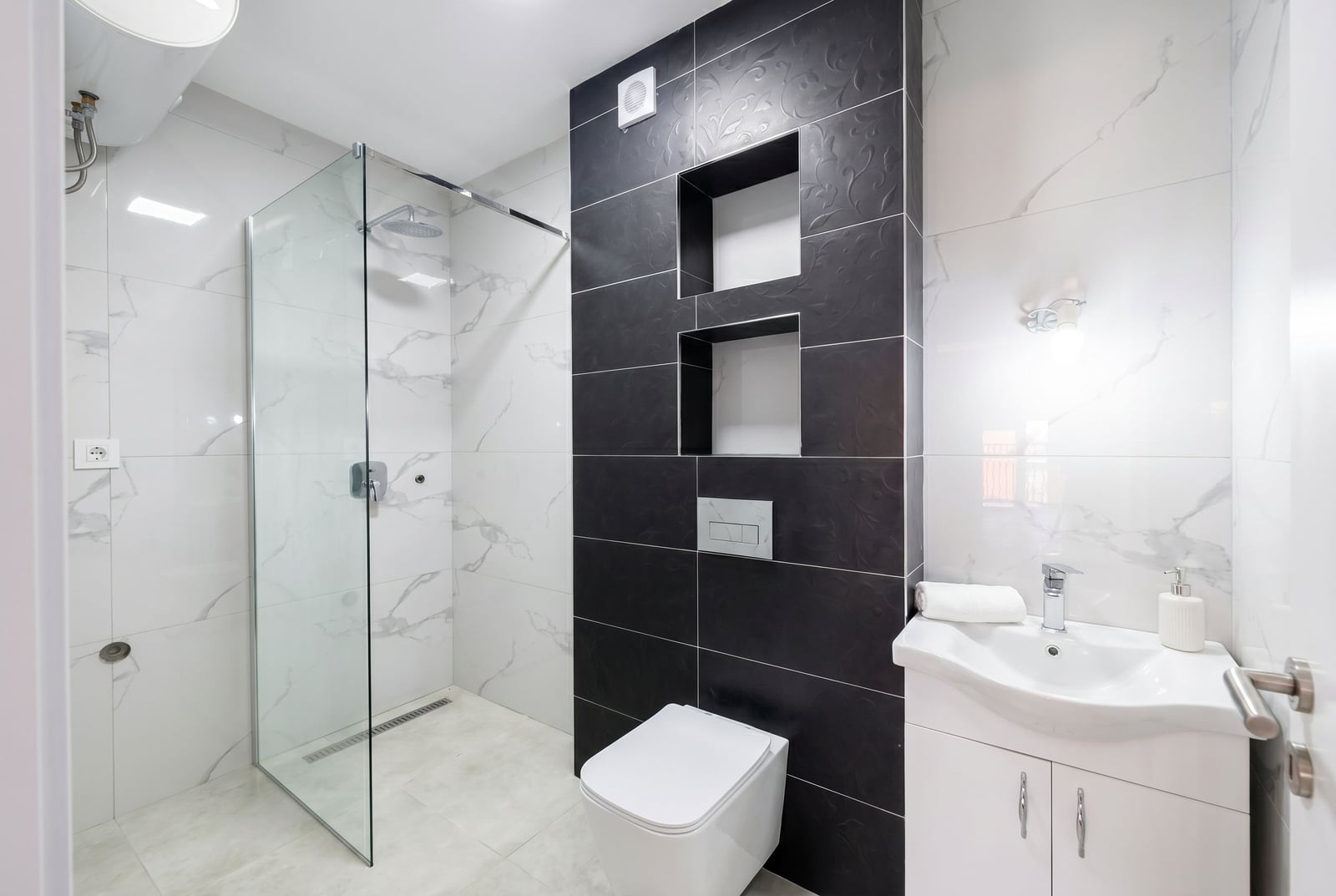 Modern bathroom in a Budva apartment, Montenegro: walk-in shower, wall-hung toilet, and stylish finishes.