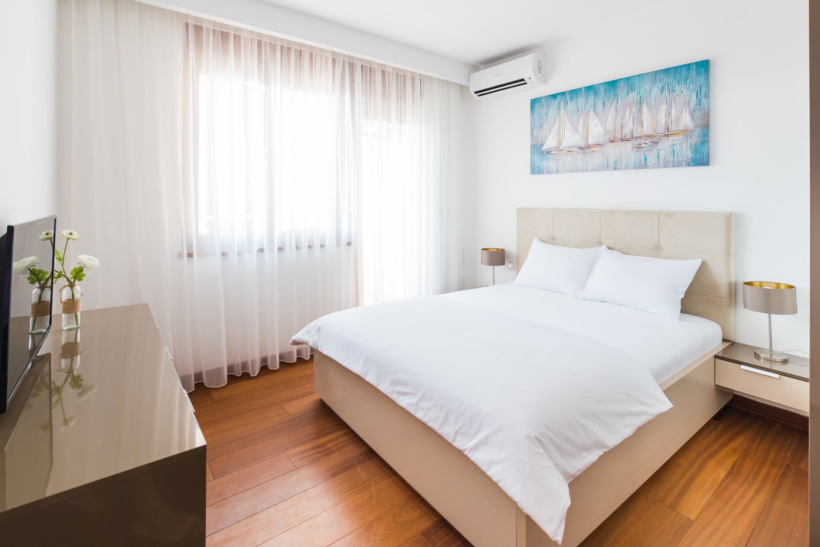 Bright bedroom with a double bed and parquet flooring in an apartment for sale in Becici, Montenegro.