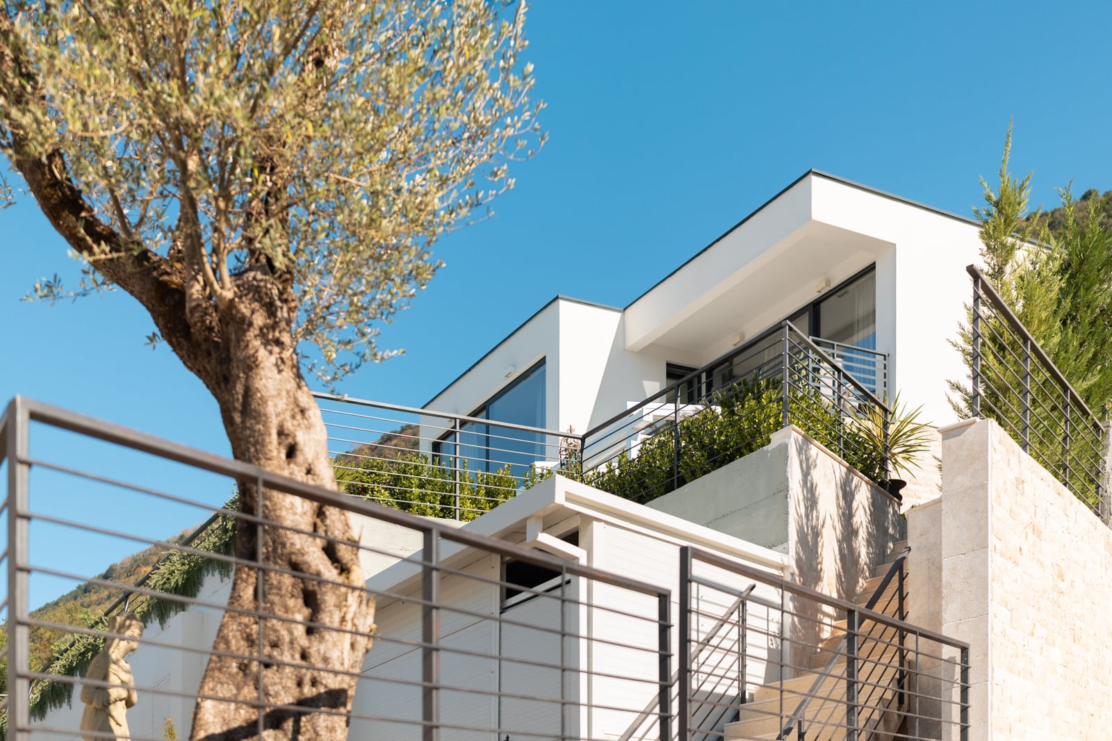 Modern townhouse with a terrace and an olive tree in Kavač, Montenegro: view of the facade and house architecture.